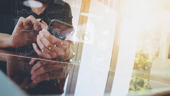 Digital transformation: Person's hands at board table on smartphone overlaid with charts