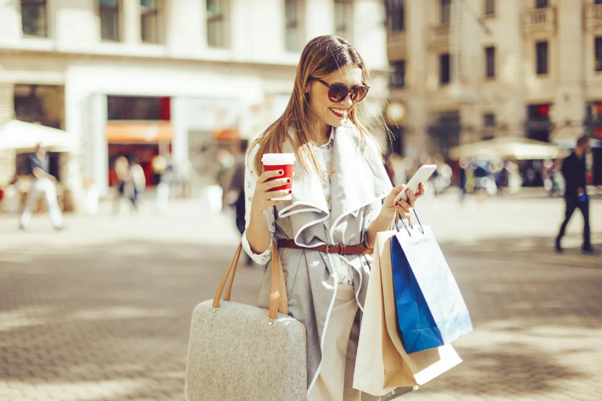 Woman checking phone after shopping